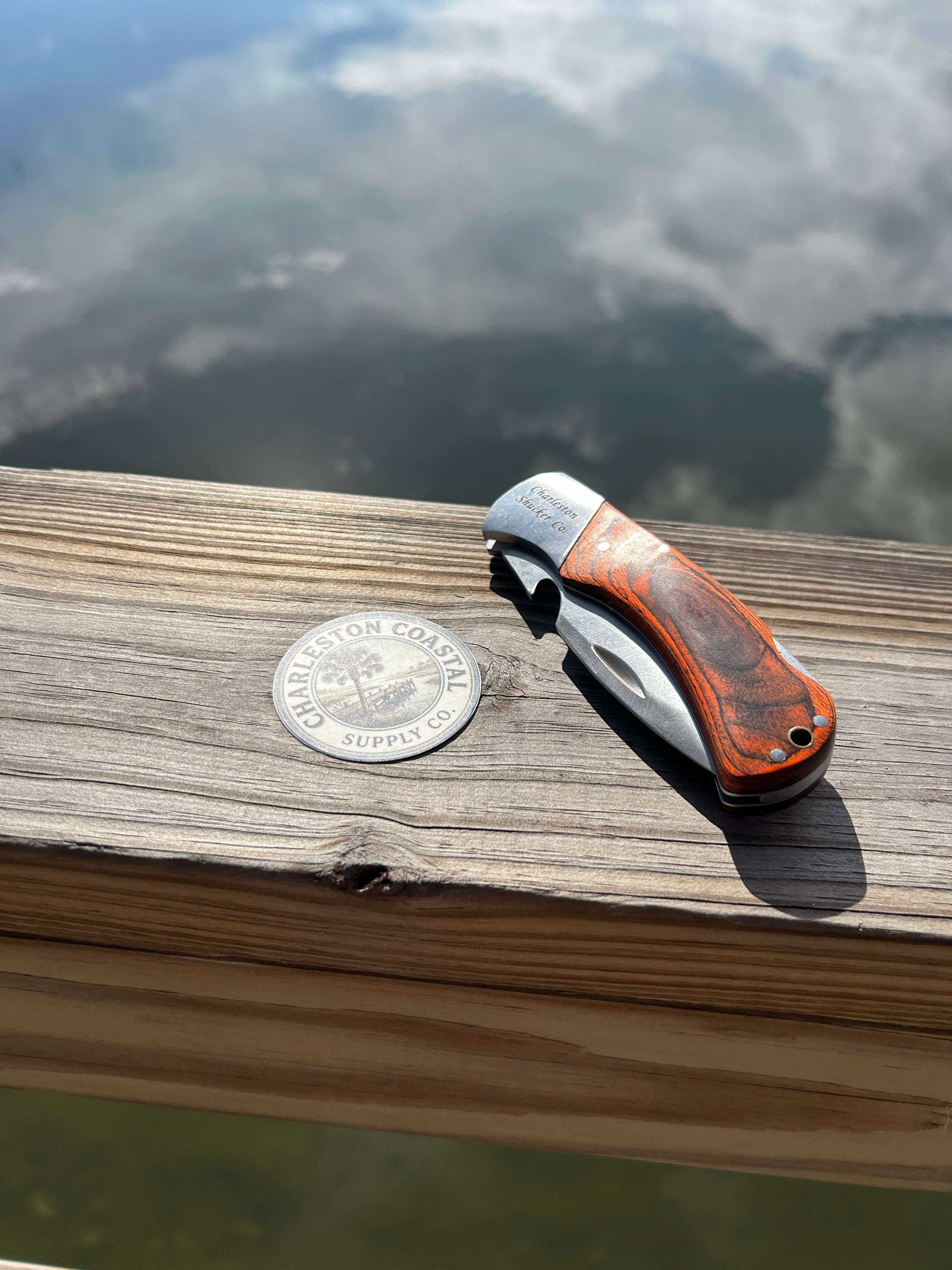 Compact folding oyster knife with stainless steel blade and protective sheath for safe, portable shucking.