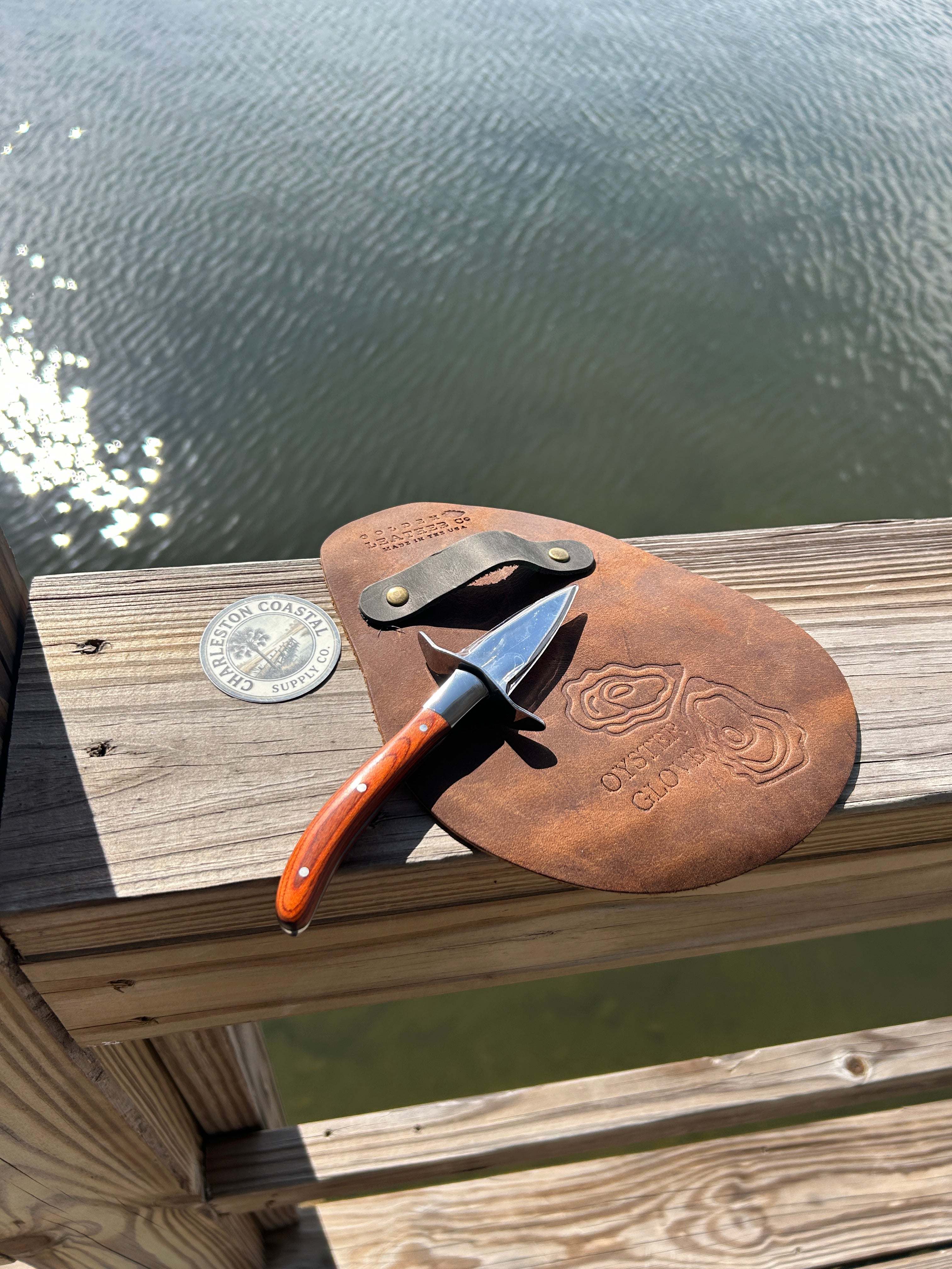 Handcrafted full-grain leather Shucks Oyster Glove with brass strap and oyster artwork for durable oyster shucking protection